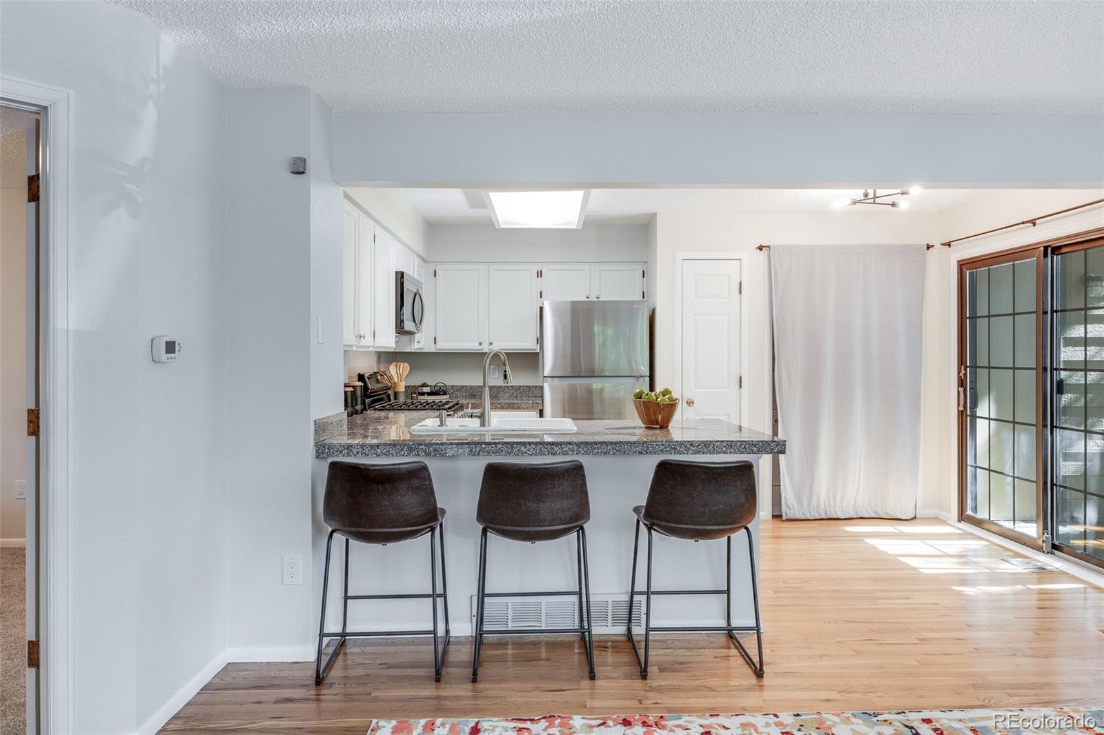 4811 White Rock Circle, Unit C Boulder, CO 80301 - Photo 7 of 19 a kitchen with stainless steel appliances kitchen island a chandelier