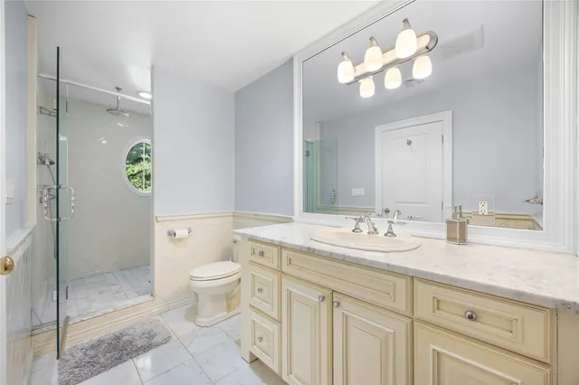 a bathroom with a toilet a sink and mirror