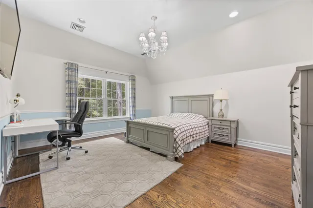 a spacious bedroom with a bed and a chandelier