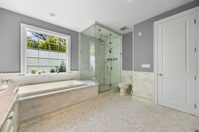 a spacious bathroom with a bathtub shower and toilet