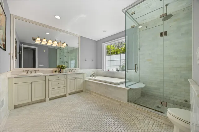 a bathroom with a granite countertop sink a toilet a mirror and shower