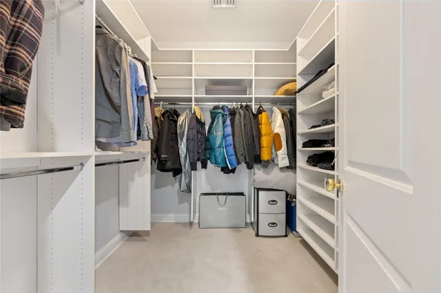 a view of walk in closet with clothes and shoes