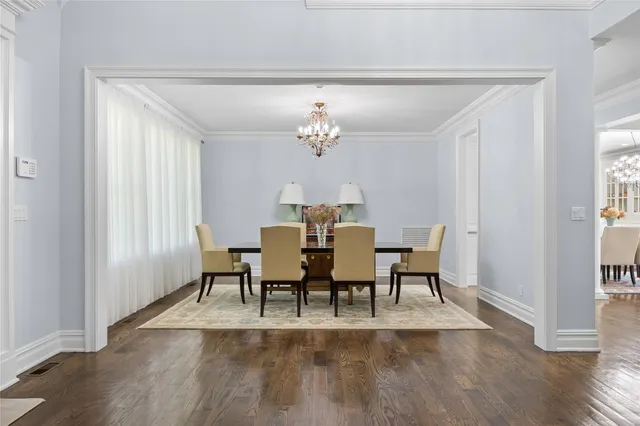 a view of a dining room with furniture a chandelier and wooden floor