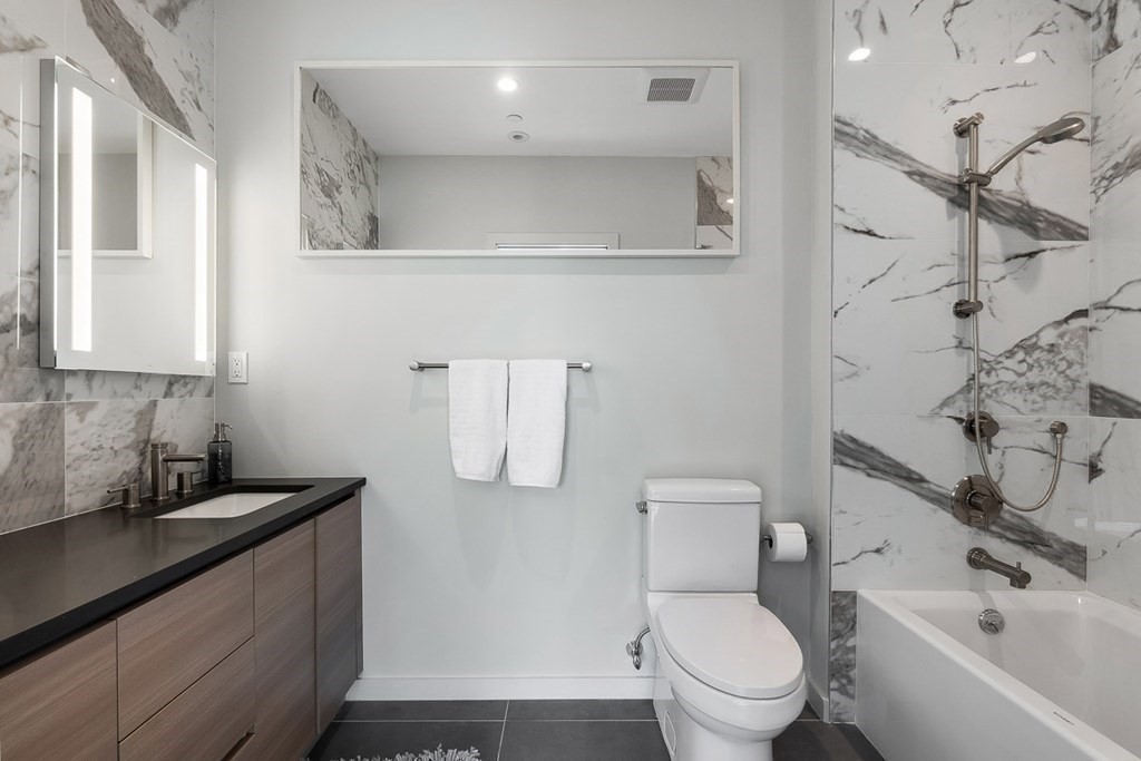100 A Street, Unit 6 Boston, MA 02127 - Photo 25 of 37 a bathroom with a granite countertop toilet sink and mirror