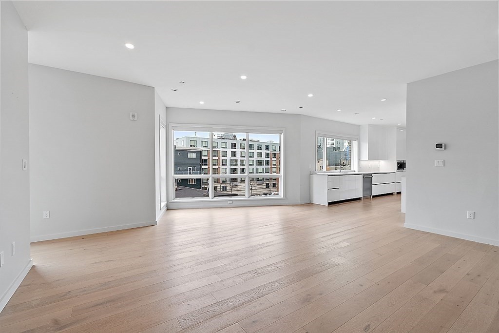 100 A Street, Unit 6 Boston, MA 02127 - Photo 5 of 37 a view of an empty room with a window and wooden floor