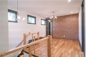 a view of a hallway with furniture and chandelier