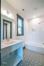 a bathroom with a sink a mirror and a bathtub