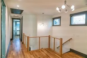 a view of a hallway with wooden floor and staircase