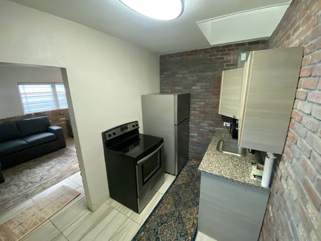 a kitchen with granite countertop a stove and a couch