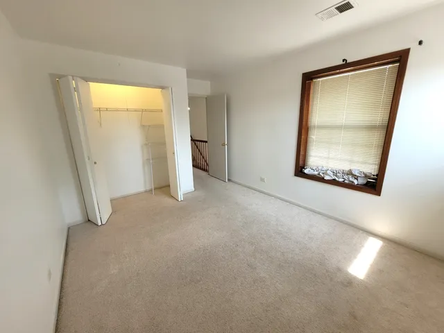an empty room with windows and closet