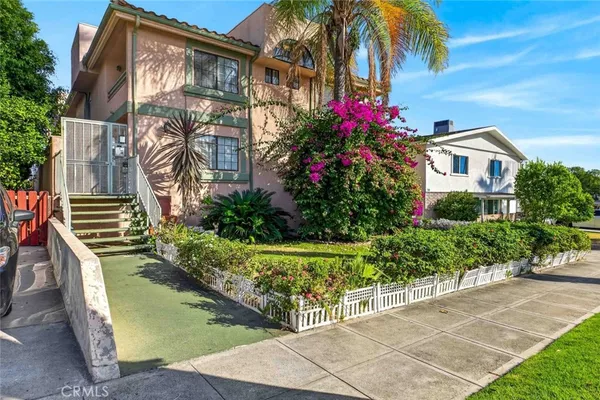 a front view of a house with a yard and potted plants