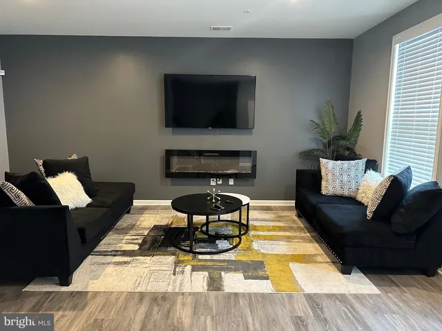 a living room with furniture a flat screen tv and a fireplace