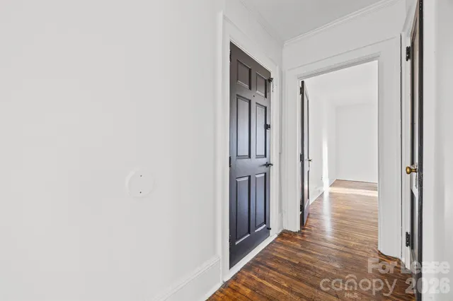 a view of a hallway with wooden floor and entryway
