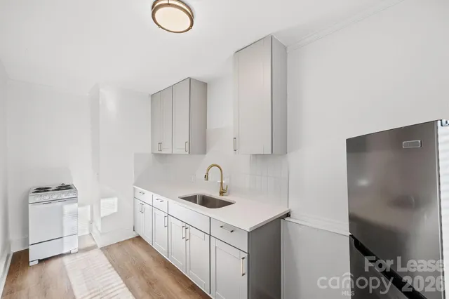 a kitchen with white cabinets and stainless steel appliances