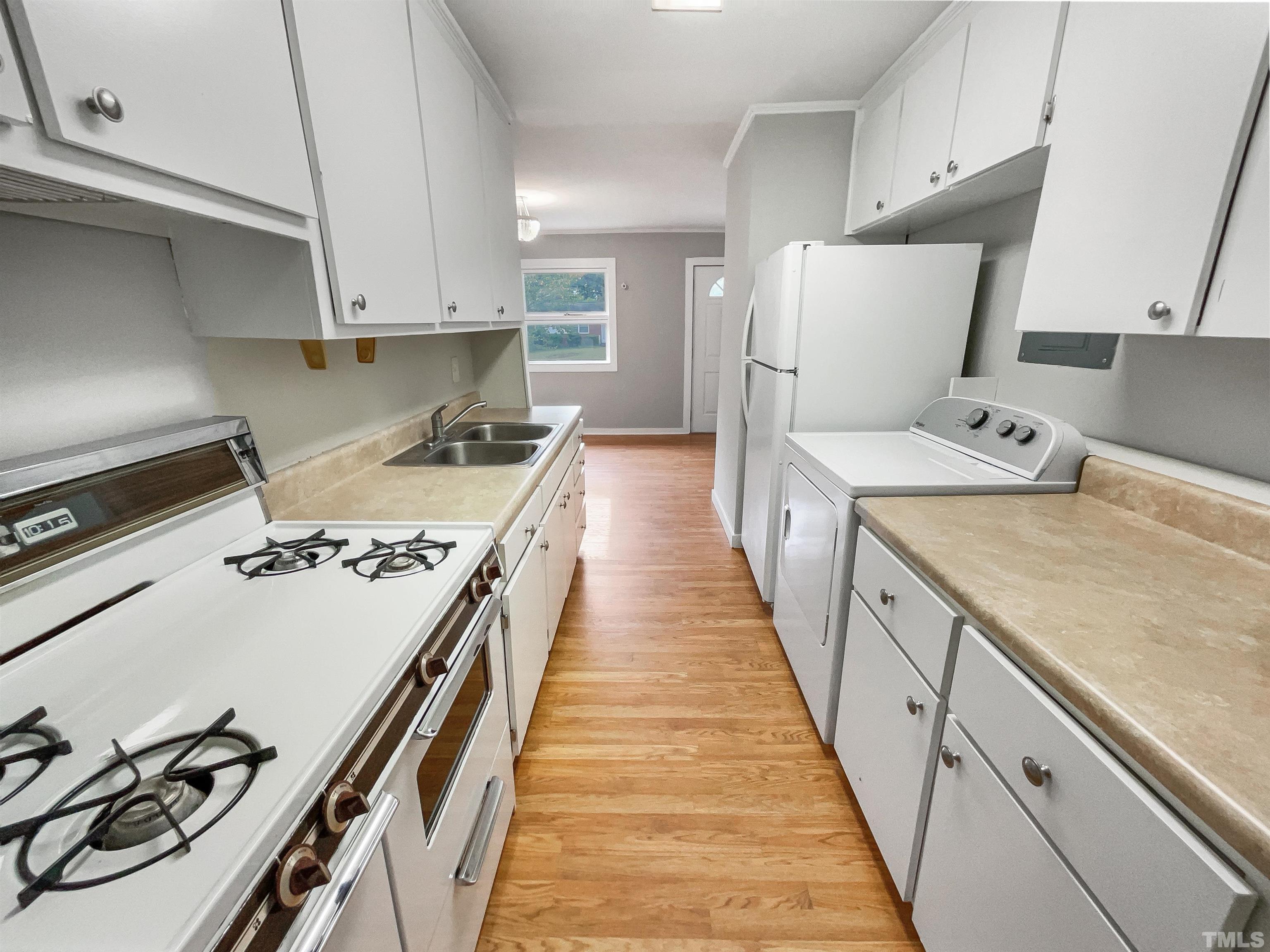 2905 Bardwell Road Raleigh, NC 27604 - Photo 4 of 17 a kitchen with kitchen island a stove a sink and a refrigerator