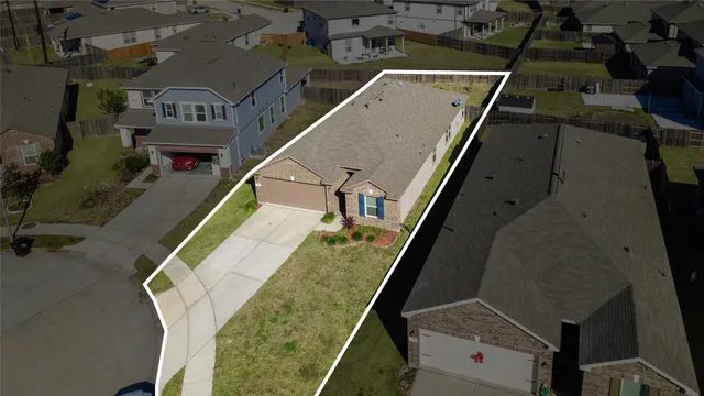 an aerial view of a house with a yard