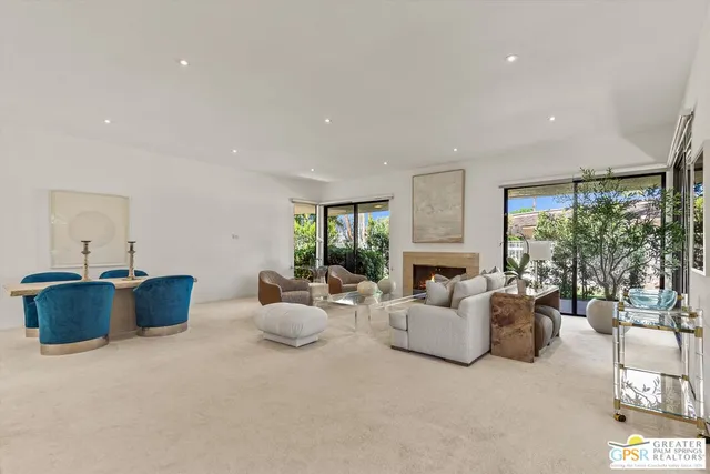 a living room with furniture fireplace and potted plants