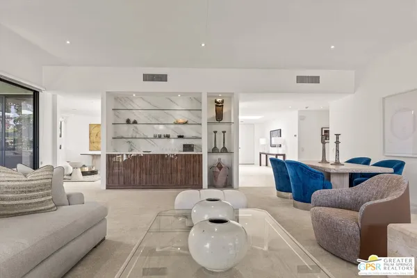 a living room with furniture a rug and kitchen view