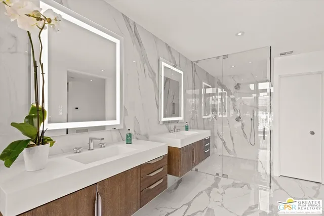 a bathroom with a double vanity sink mirror and shower