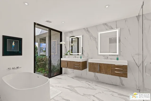 a spacious bathroom with a tub sink and mirror