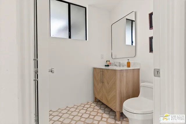 a bathroom with a toilet sink and mirror