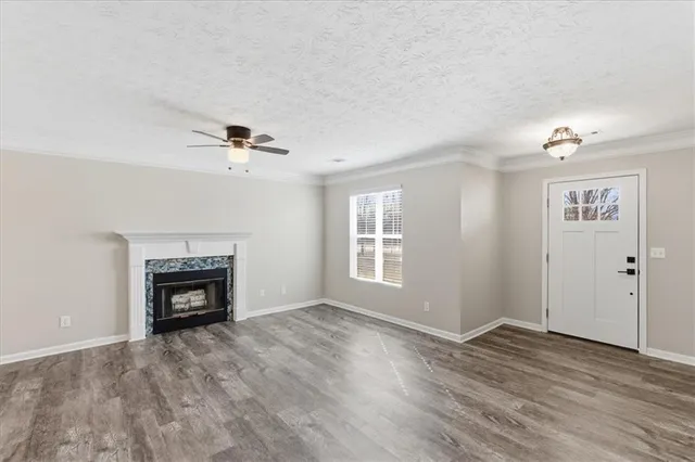 a kitchen with a sink dishwasher a refrigerator and white cabinets with wooden floor
