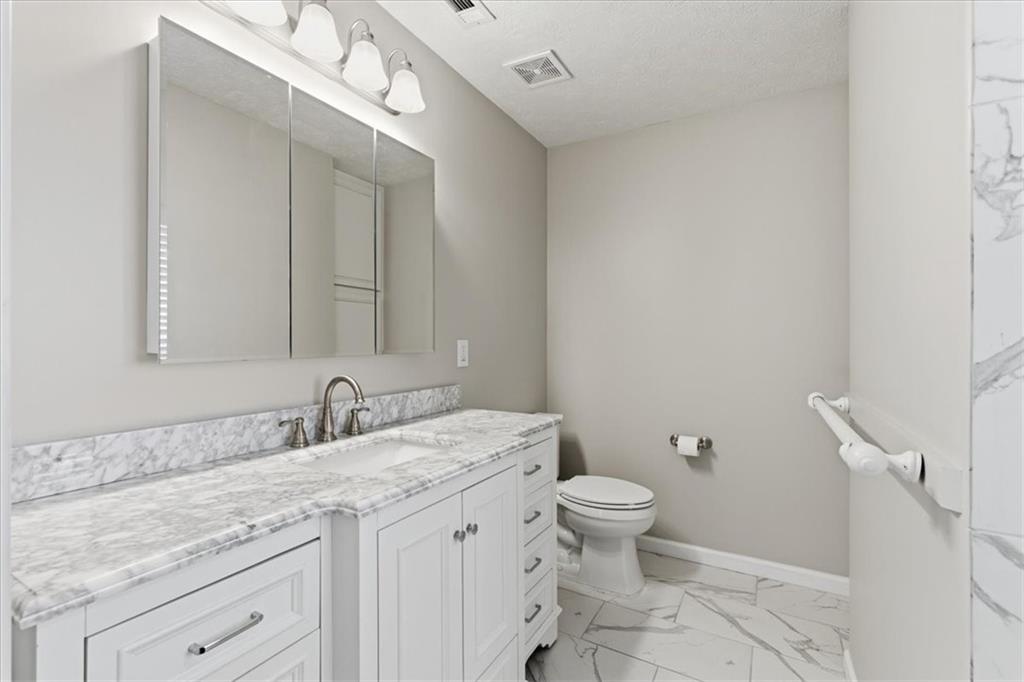 125 Governor Lane Temple, GA 30179 - Photo 32 of 57 a bathroom with a granite countertop sink a toilet and a mirror