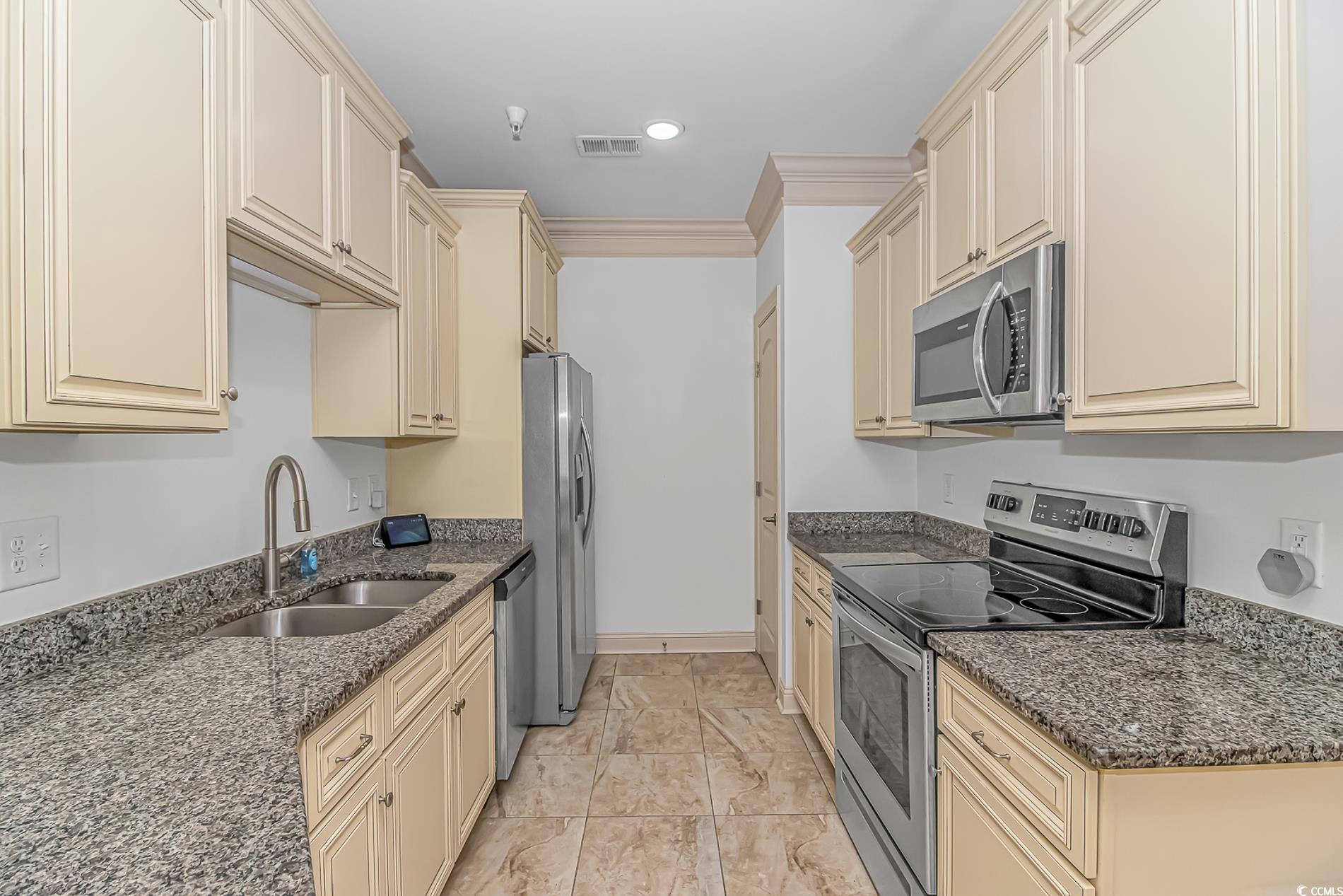 128 Puffin Drive, Unit 3A Pawleys Island, SC 29585 - Photo 16 of 30 Kitchen with cream cabinetry, stainless steel appliances, dark stone counters, ornamental molding, and recessed lighting