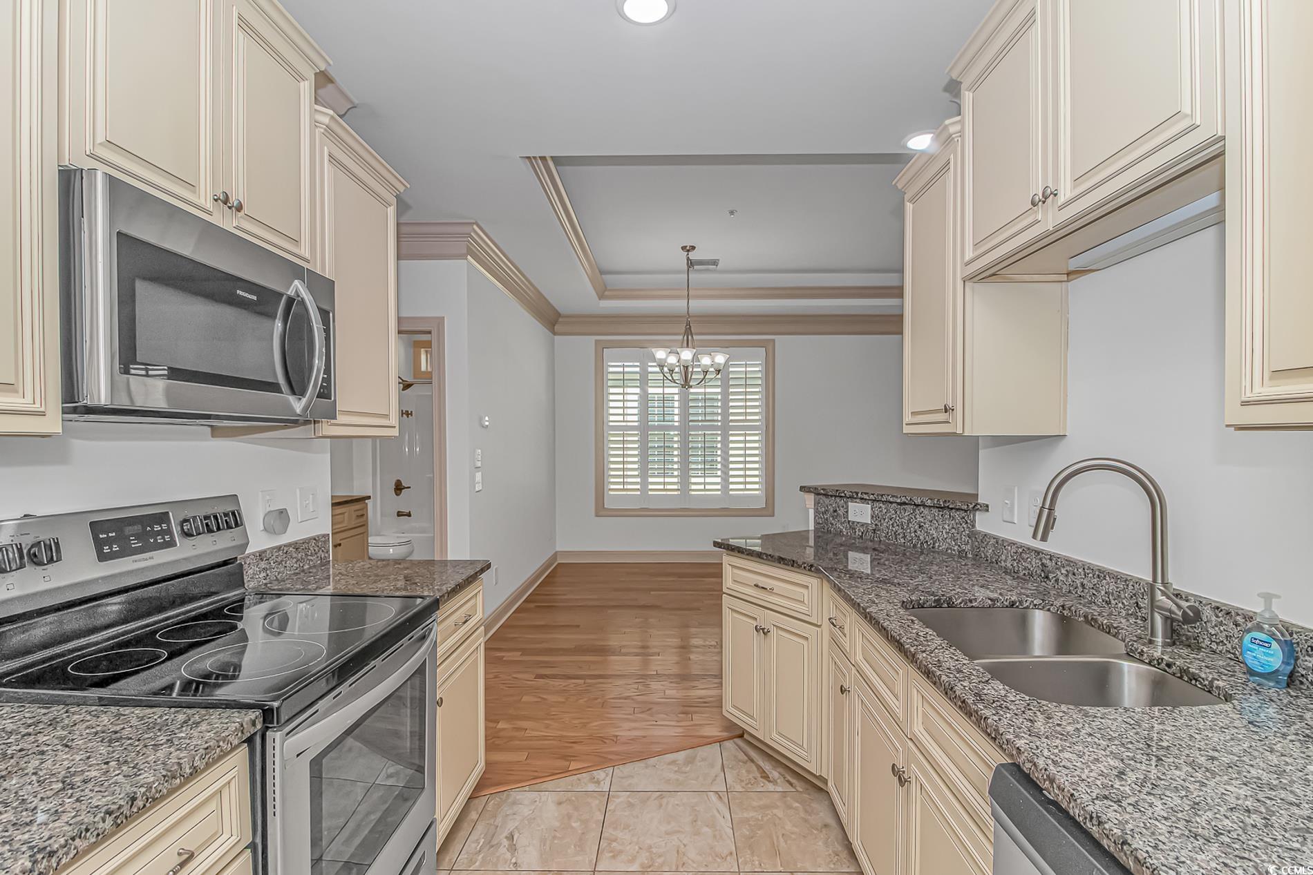 128 Puffin Drive, Unit 3A Pawleys Island, SC 29585 - Photo 17 of 30 Kitchen with cream cabinetry, appliances with stainless steel finishes, dark stone countertops, pendant lighting, and crown molding