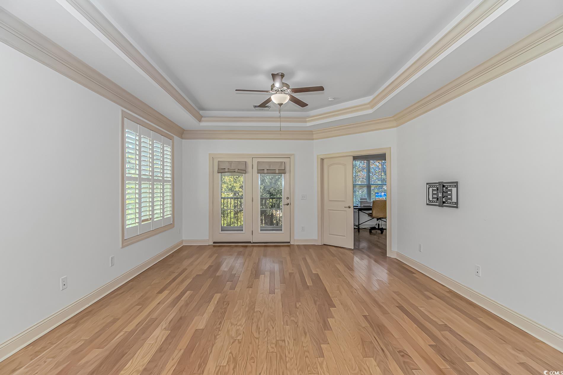 128 Puffin Drive, Unit 3A Pawleys Island, SC 29585 - Photo 20 of 30 room featuring ornamental molding, plenty of natural light, light wood-type flooring, a tray ceiling, and ceiling fan