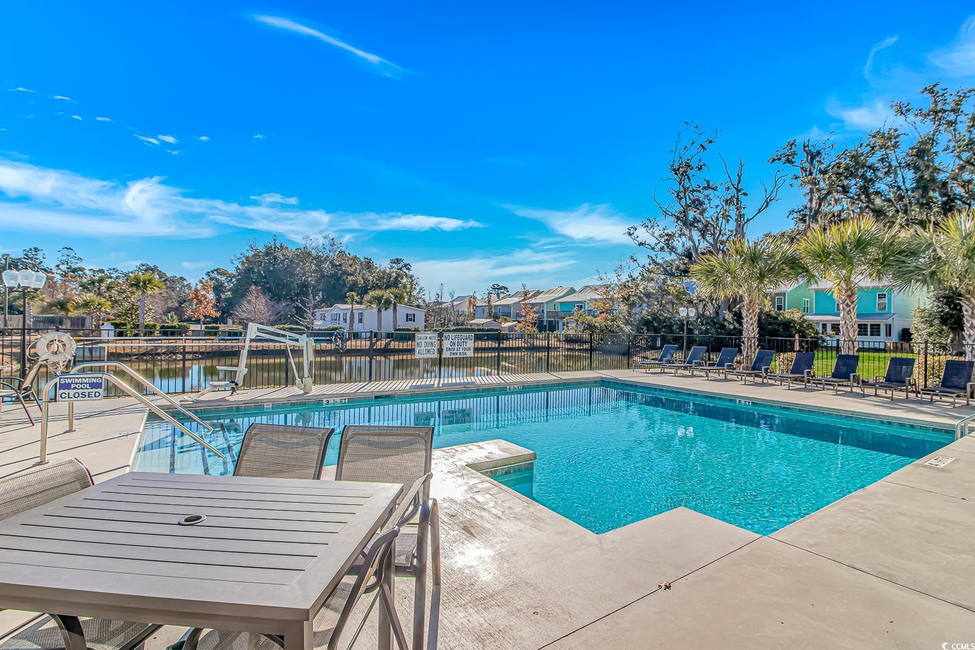 128 Puffin Drive, Unit 3A Pawleys Island, SC 29585 - Photo 30 of 30 Community pool featuring a patio area, a water view, and a residential view