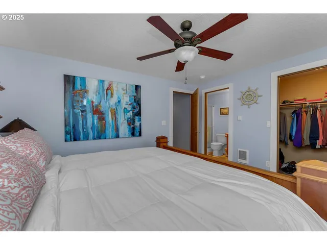 a bedroom with a large bed and a chandelier