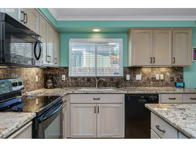 a kitchen with stainless steel appliances granite countertop a sink stove and cabinets