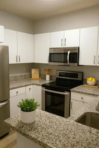 a kitchen with stainless steel appliances kitchen island granite countertop a stove a sink and a microwave