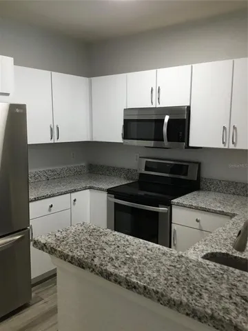 a kitchen with stainless steel appliances granite countertop a sink and a stove