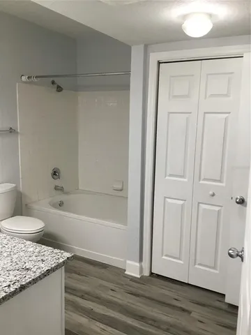 a bathroom with a granite countertop sink and mirror with bathtub