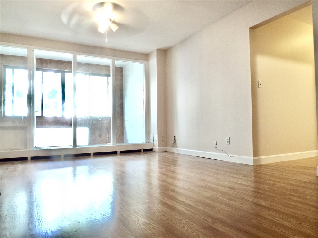 32 Juniper Street, Unit 98 Brookline, MA 02445 - Photo 7 of 17 a view of an empty room with wooden floor and a window