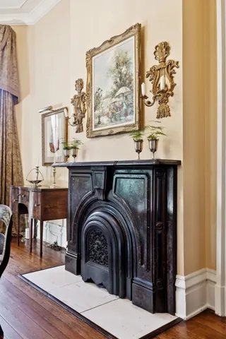 a dining room with wooden floor a chandelier a wooden table and chairs