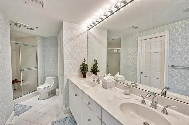 a bathroom with a double vanity sink toilet and shower