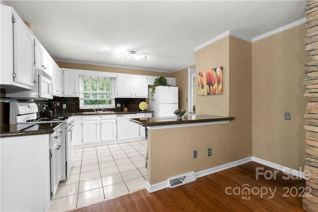 1705 Tyvola Road Charlotte, NC 28210 - Photo 12 of 40 a kitchen with stainless steel appliances granite countertop a stove a sink and a microwave