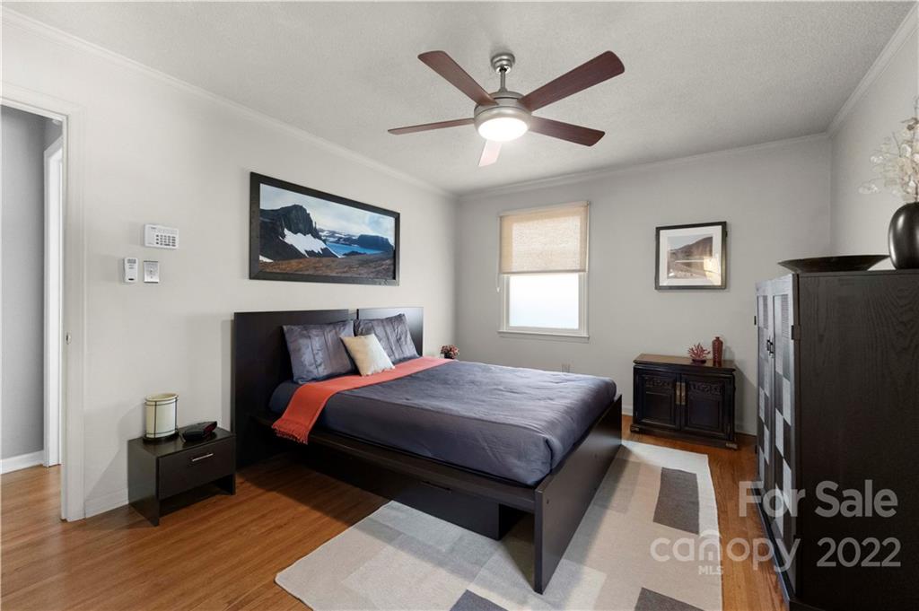 1705 Tyvola Road Charlotte, NC 28210 - Photo 23 of 40 a bedroom with a bed and a chandelier