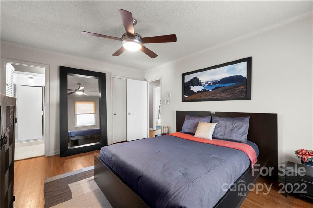 1705 Tyvola Road Charlotte, NC 28210 - Photo 24 of 40 a bedroom with a large bed and a chandelier