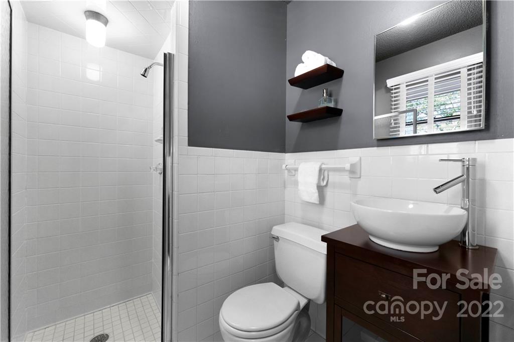 1705 Tyvola Road Charlotte, NC 28210 - Photo 25 of 40 a bathroom with a toilet a sink and mirror