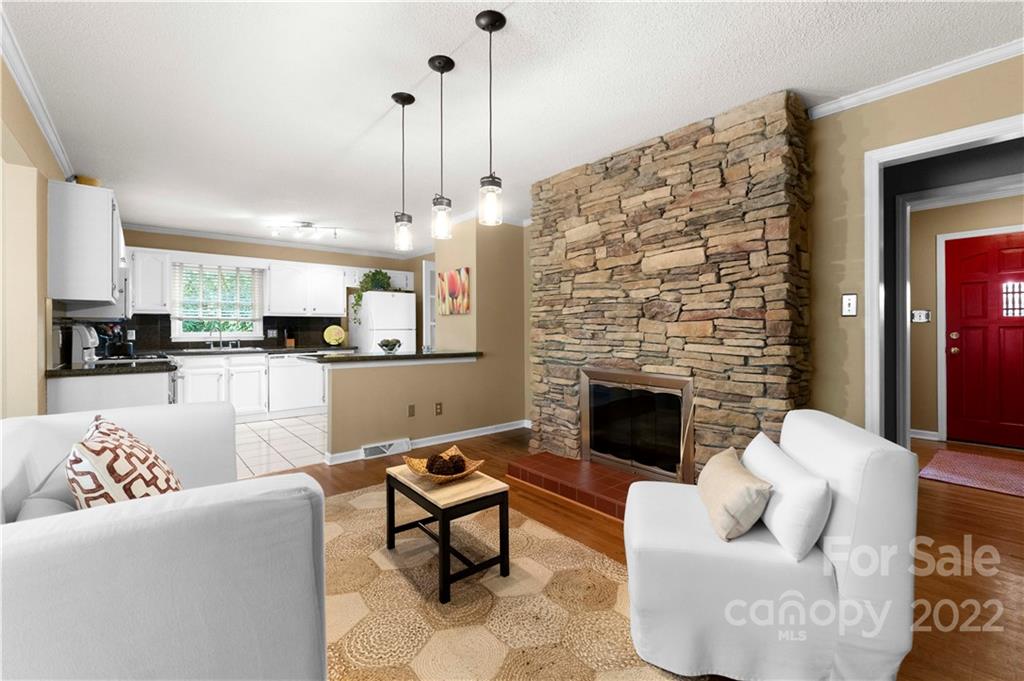 1705 Tyvola Road Charlotte, NC 28210 - Photo 7 of 40 a living room with furniture a fireplace and kitchen view
