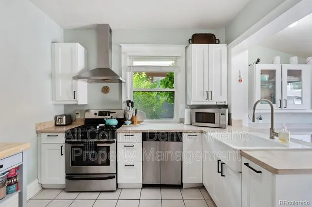 a kitchen with white cabinets and appliances