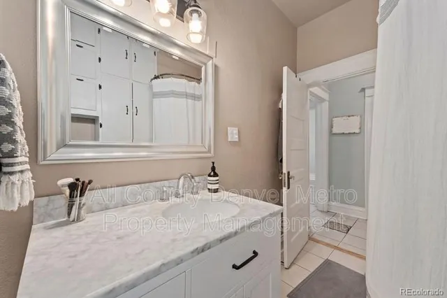 a bathroom with a granite countertop sink and a mirror