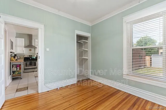 a view of a room with wooden floor and a kitchen