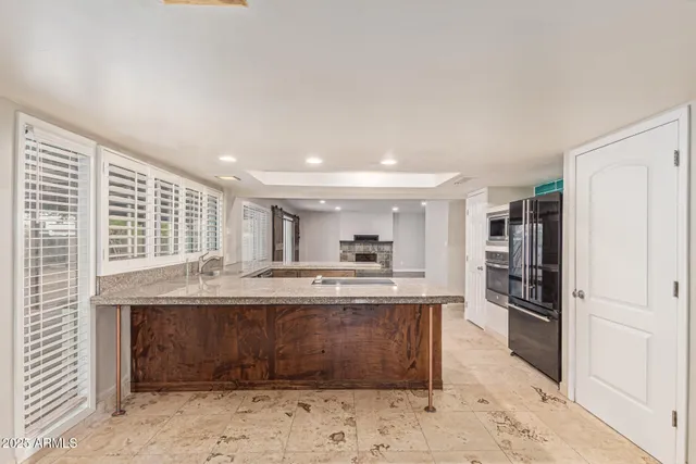 a large kitchen with kitchen island a sink stainless steel appliances and cabinets