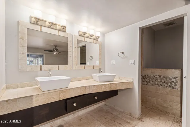 a bathroom with a double vanity sink mirror and shower