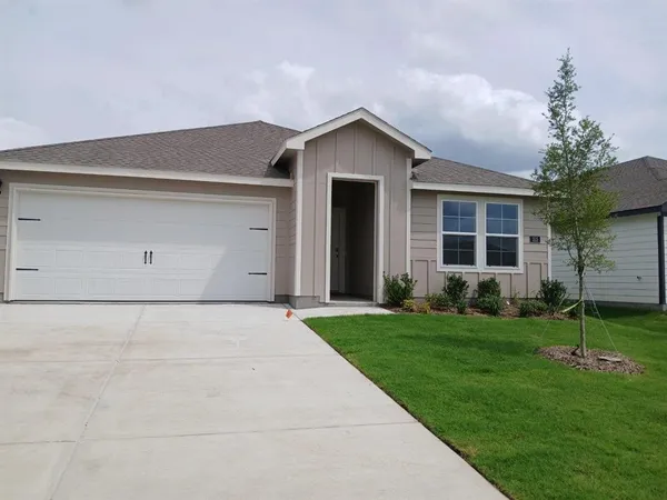 front view of a house with a yard and garage
